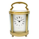 Late 20th century carriage timepiece clock, polished brass case of oval form glazed with bevelled gl