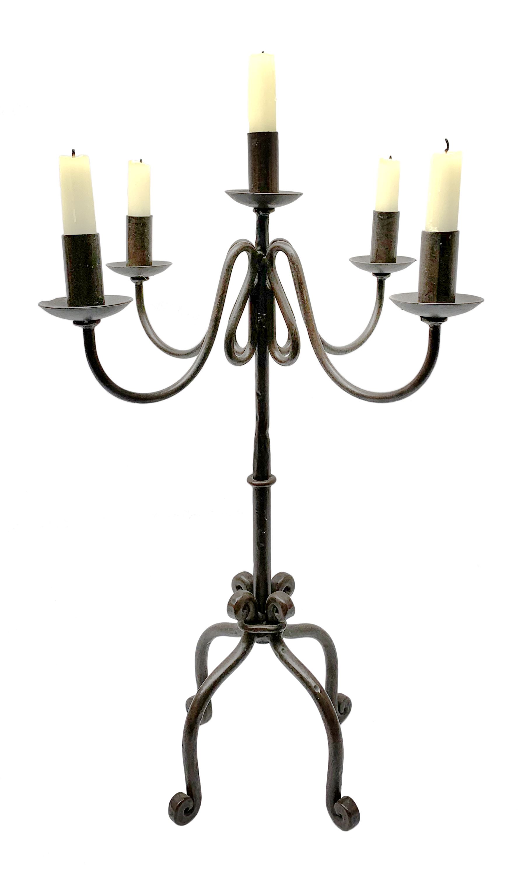 A patinated wrought iron five branch candelabra