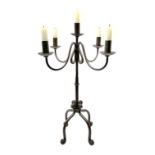 A patinated wrought iron five branch candelabra