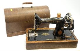 A cased vintage Singer hand crank sewing machine.