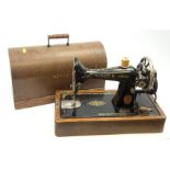 A cased vintage Singer hand crank sewing machine.