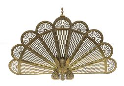 A brass peacock fire screen