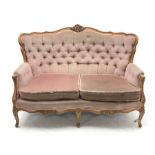 20th century beech framed French style two seat settee, the shaped and moulded frame carved with fol