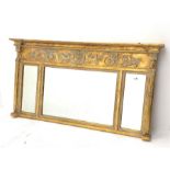 Regency style gilt wall mirror, scrolled foliate and mask decorated frieze over three sectional mirr
