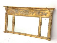 Regency style gilt wall mirror, scrolled foliate and mask decorated frieze over three sectional mirr