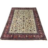 Kashan beige ground rug, trailing foliage field, red border with repeating pattern