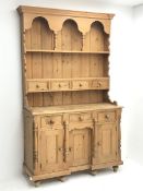 Solid waxed pine dresser, raised two heights plate rack with small drawers, the base fitted with thr