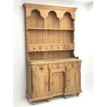 Solid waxed pine dresser, raised two heights plate rack with small drawers, the base fitted with thr