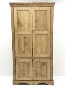 Traditional pine larder cupboard, projecting moulded cornice over four panelled doors, shaped plinth