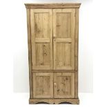 Traditional pine larder cupboard, projecting moulded cornice over four panelled doors, shaped plinth