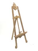 Unfinished teak floor standing adjustable picture easel with ornate carved cartouche pediment, suppo