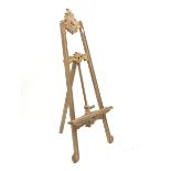 Unfinished teak floor standing adjustable picture easel with ornate carved cartouche pediment, suppo