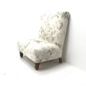 Wide seat nursing chair upholstered in an ivory ground fabric with floral pattern, turned supports,