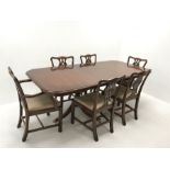 Wade Georgian style mahogany twin pedestal extending dining table, turned supports on shaped brass c