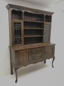 Early 20th century oak dresser, raised three tier plate rack flanked by lead glazed display cabinets