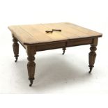 Edwardian oak telescopic extending dining table, canted rectangular top with moulded edge, on turned