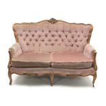 20th century beech framed French style two seat settee, the shaped and moulded frame carved with fol