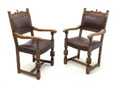 Pair 20th century oak armchairs, shaped cresting rail carved with flower heads, dished seats and bac