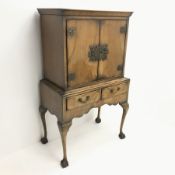 Georgian style walnut cocktail cabinet on stand, two cupboards enclosing glazed shelf above two draw