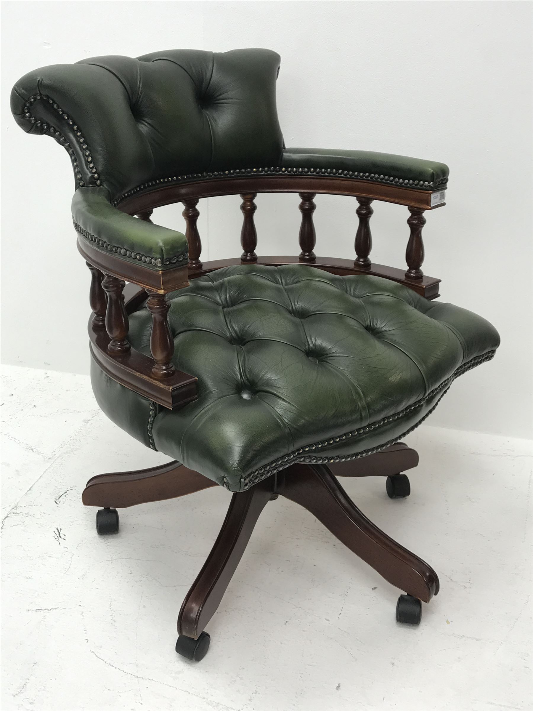 Reproduction mahogany captains office swivel armchair upholstered in buttoned green leather, W64cm