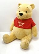 Very large plush covered figure of Winnie The Pooh in a seated position with black plastic eyes