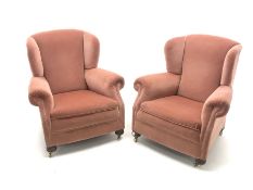 Pair early 20th century wing back armchair upholstered in a coral fabric