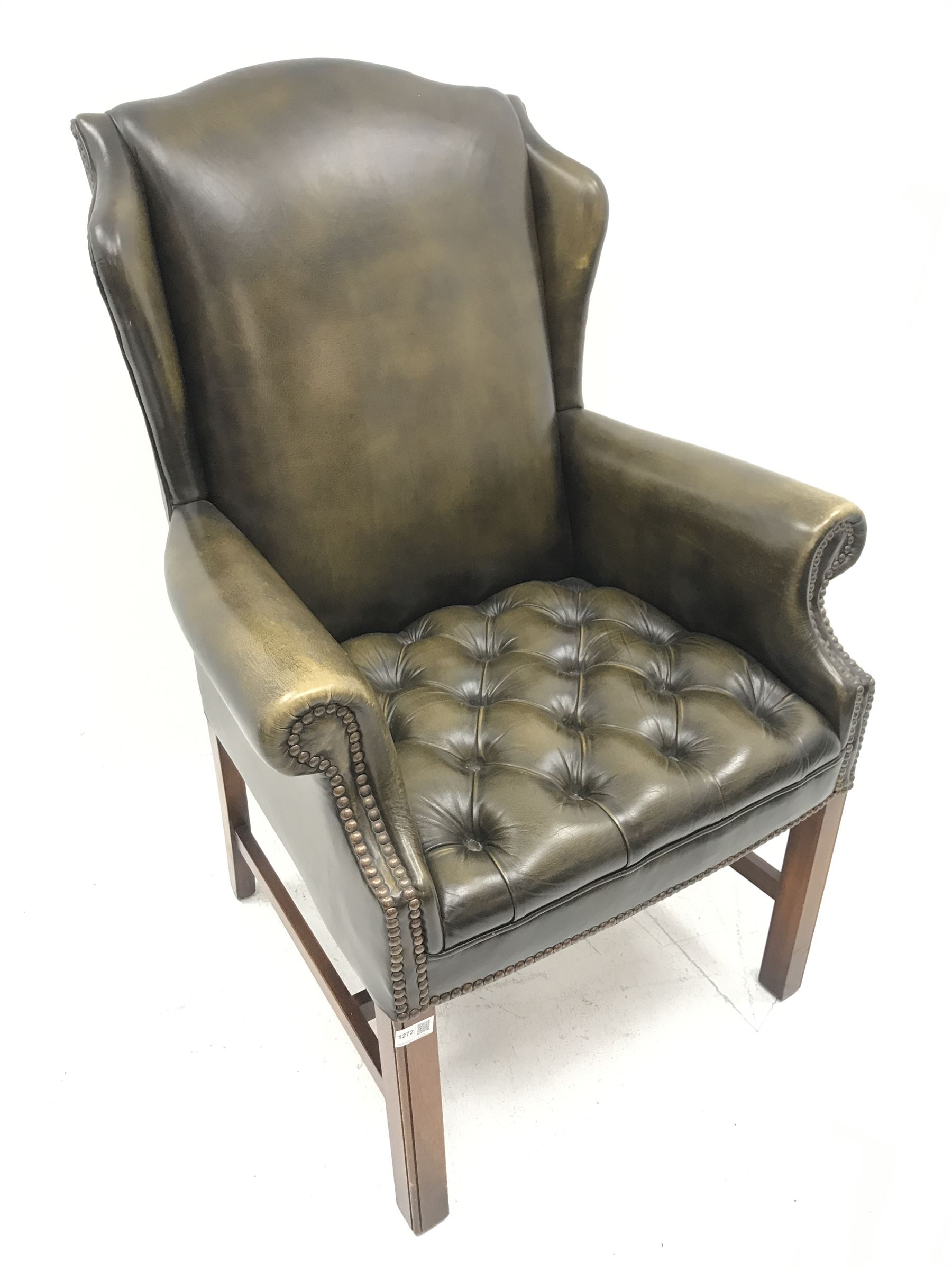Georgian style wing back armchair upholstered in deep buttoned and studded green leather