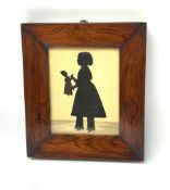 A Victorian silhouette depicting a young girl holding a doll