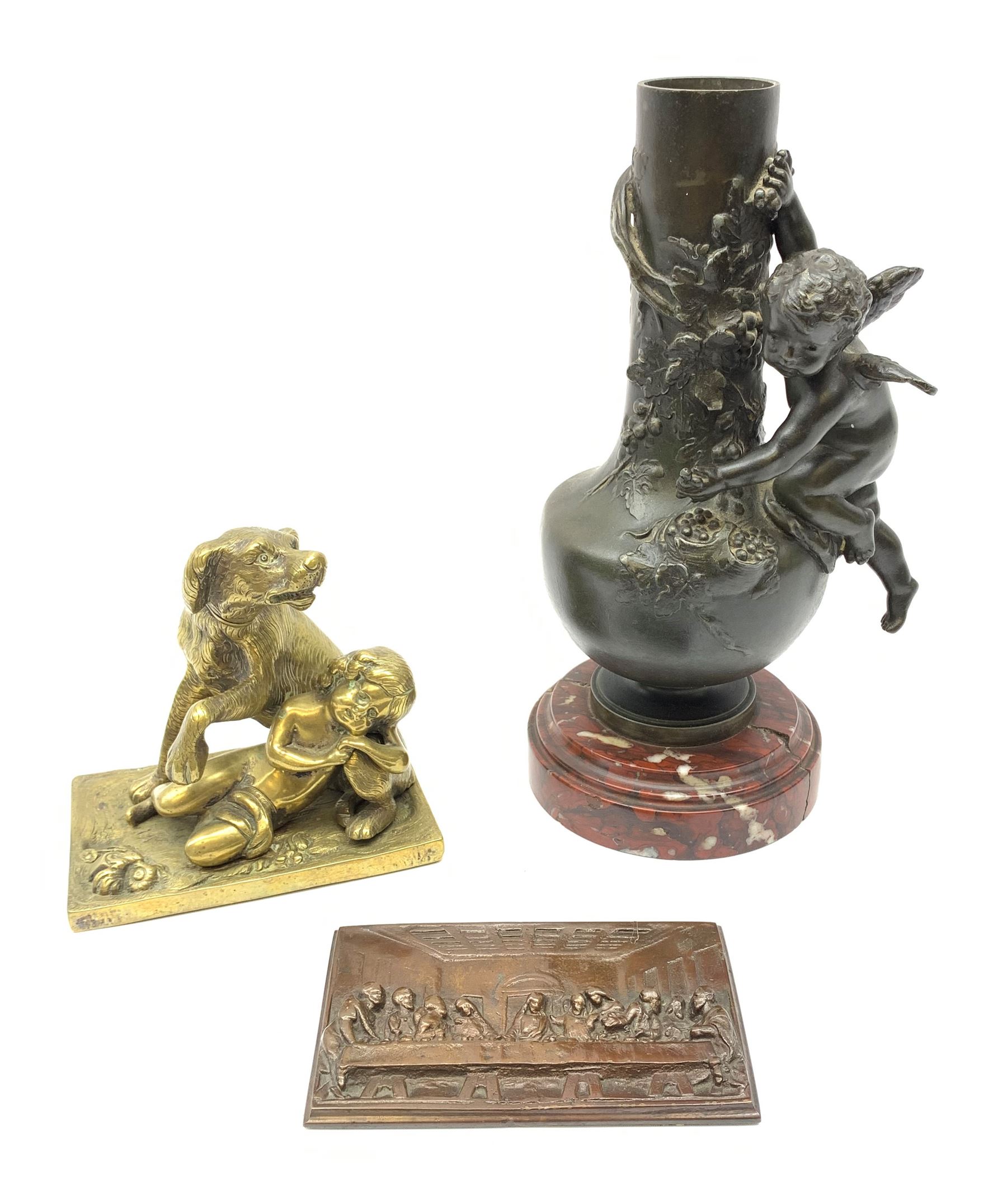 A bronzed spelter vase detailed with a fruiting vine and mounted with a cherub