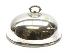 A large silver plated meat dome with scrolled handle and beaded decoration