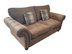 Two seat sofa upholstered in studded and buttoned suede fabric