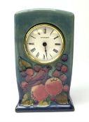A Moorcroft mantel clock decorated in the Finches pattern upon a merging light and dark blue ground