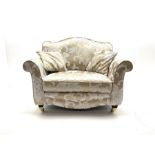 Snuggler armchair upholstered in a pale gold ground fabric with floral pattern
