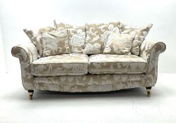 Two seat sofa upholstered in a pale gold ground fabric with floral pattern