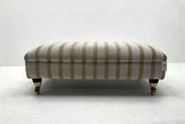 Footstool upholstered in a pale gold ground fabric with floral pattern