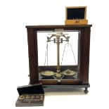 Set of laboratory balance scales by Reynolds & Branson in mahogany case with upward sliding front do