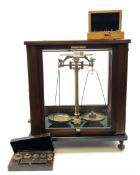 Set of laboratory balance scales by Reynolds & Branson in mahogany case with upward sliding front do