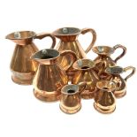 Eight graduated copper haystack jugs