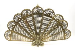 A brass peacock fire screen