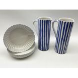 A pair of large pottery jugs with decorated with blue vertical stripes upon a white ground