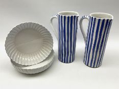 A pair of large pottery jugs with decorated with blue vertical stripes upon a white ground