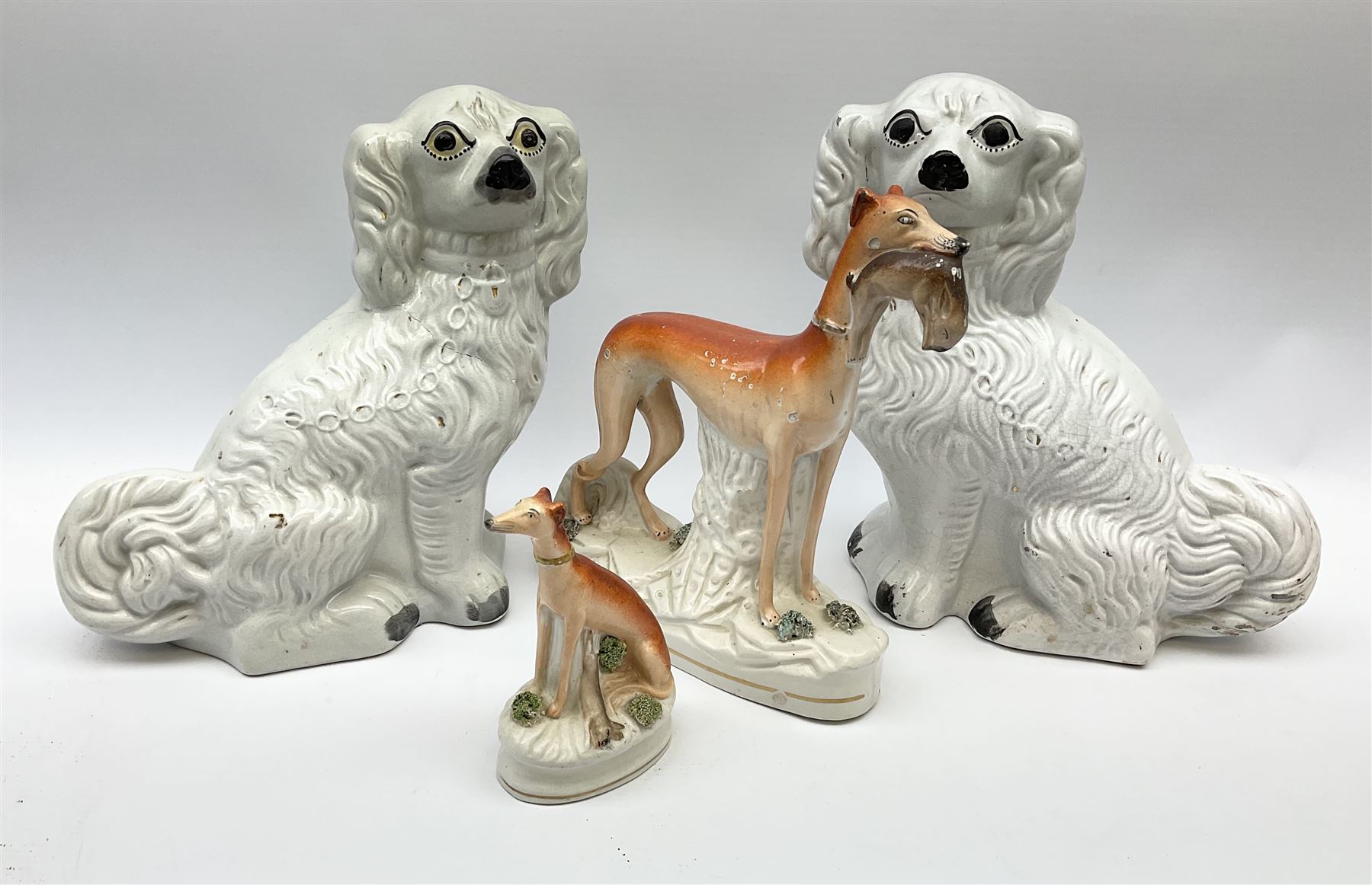 A pair of Victorian Staffordshire white glazed spaniels