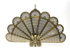 A brass peacock fire screen