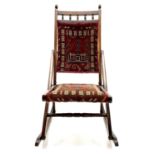 19th/20th century beech framed folding rocking chair with Persian saddle bag covers