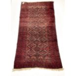 Persian red ground rug with repeating lozenge design