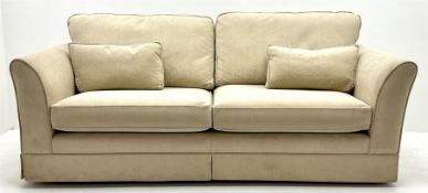 Large three seat sofa upholstered in cream fabric