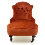 Victorian nursing chair upholstered in a buttoned terracotta fabric