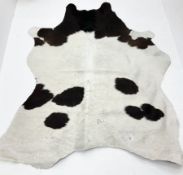 Dark brown and white patterned cow hide rug