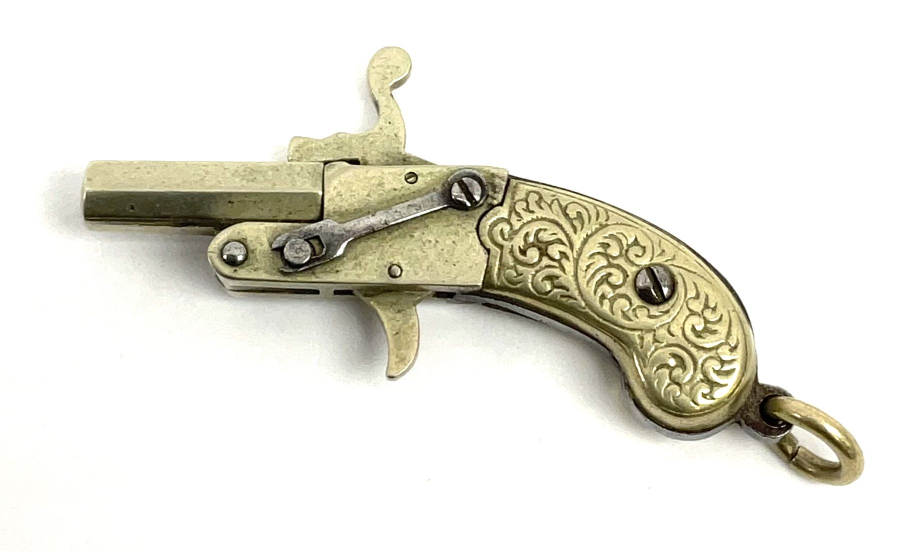 Miniature all nickel .22 pin fire single shot pistol with engraved grip and suspension ring to the b