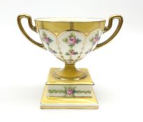 An early 20th century Minton pedestal cup with twin handles